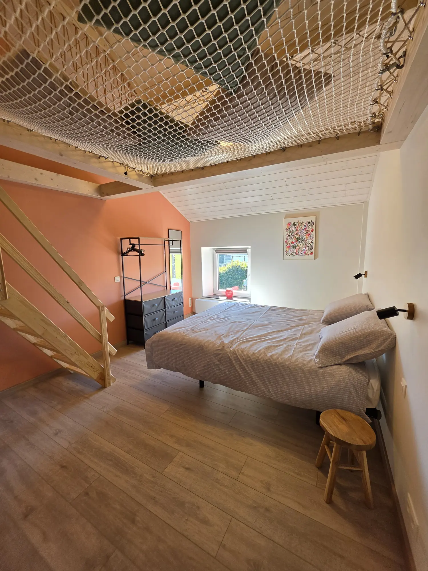 Chambre sous les poutres, avec le filet d’habitation au-dessus du lit