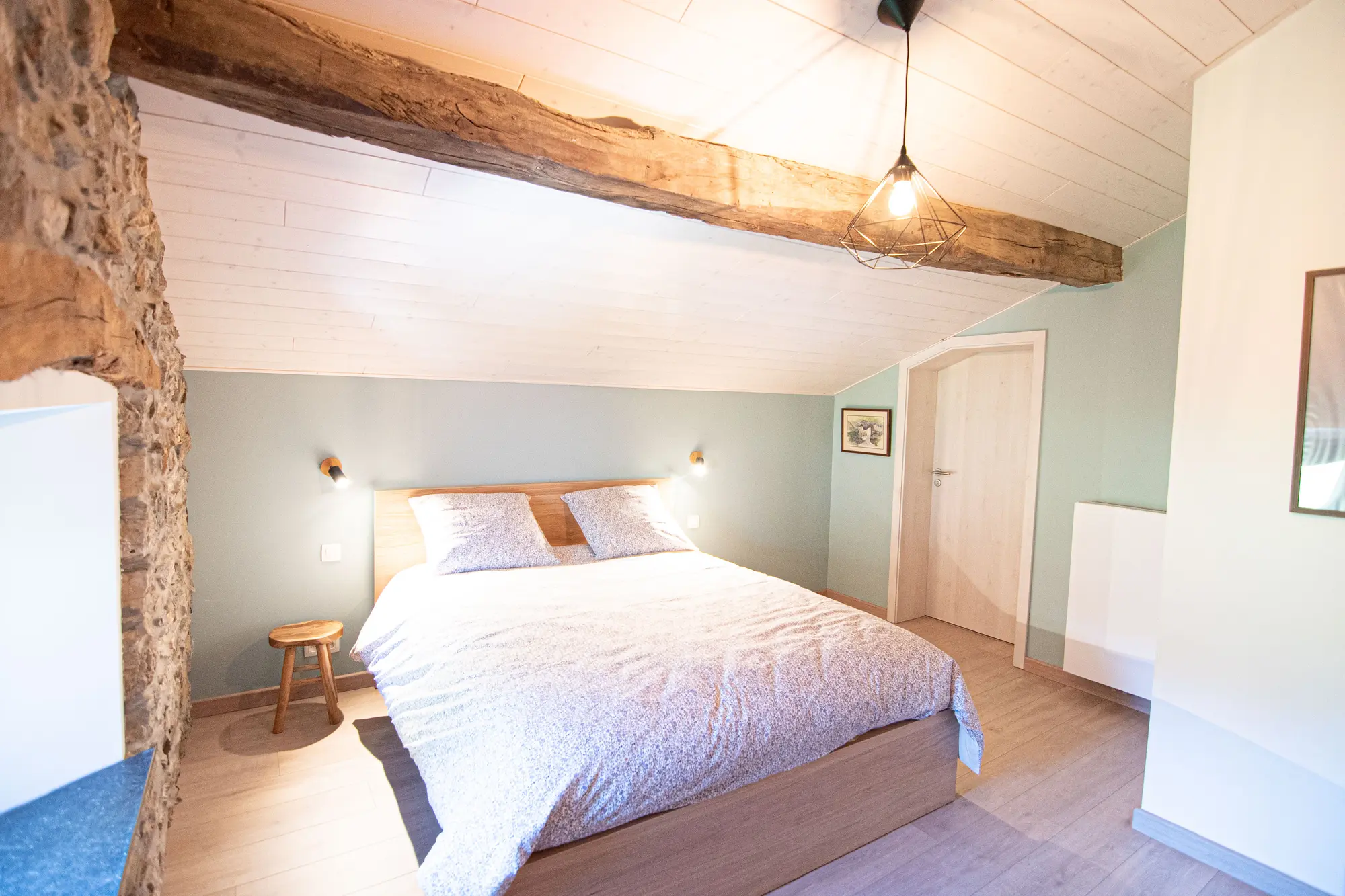 Chambre sous les poutres apparentes, avec un grand lit