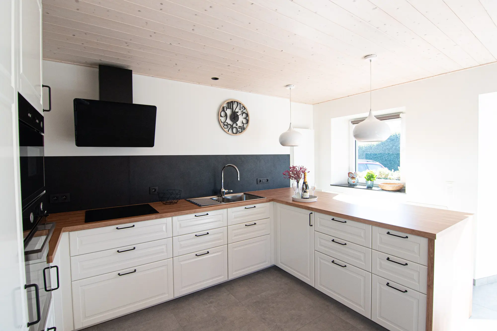 Cuisine équipée avec plans de travail en bois et rangements blancs