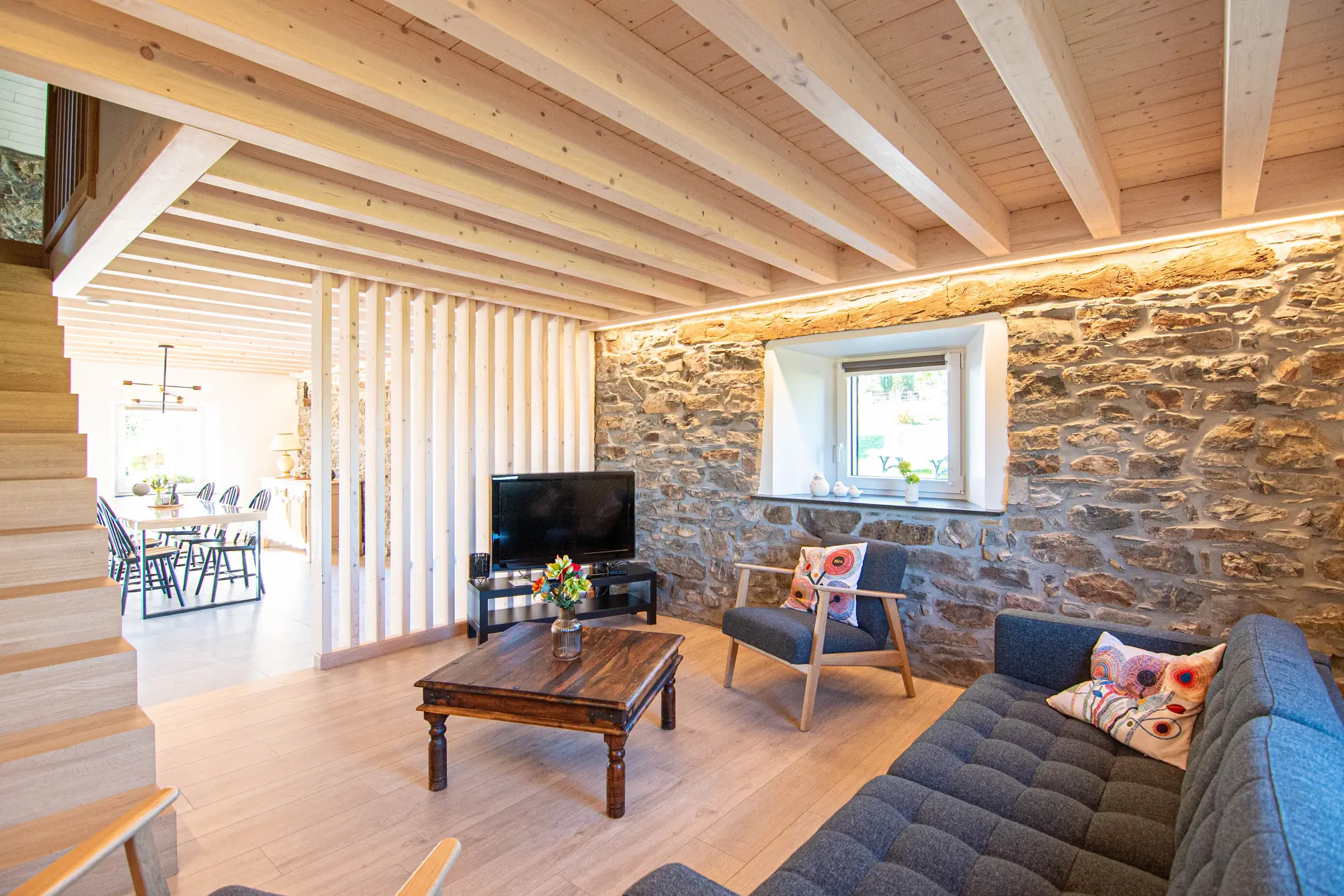 Salon vu dans son ensemble avec un grand mur en pierre