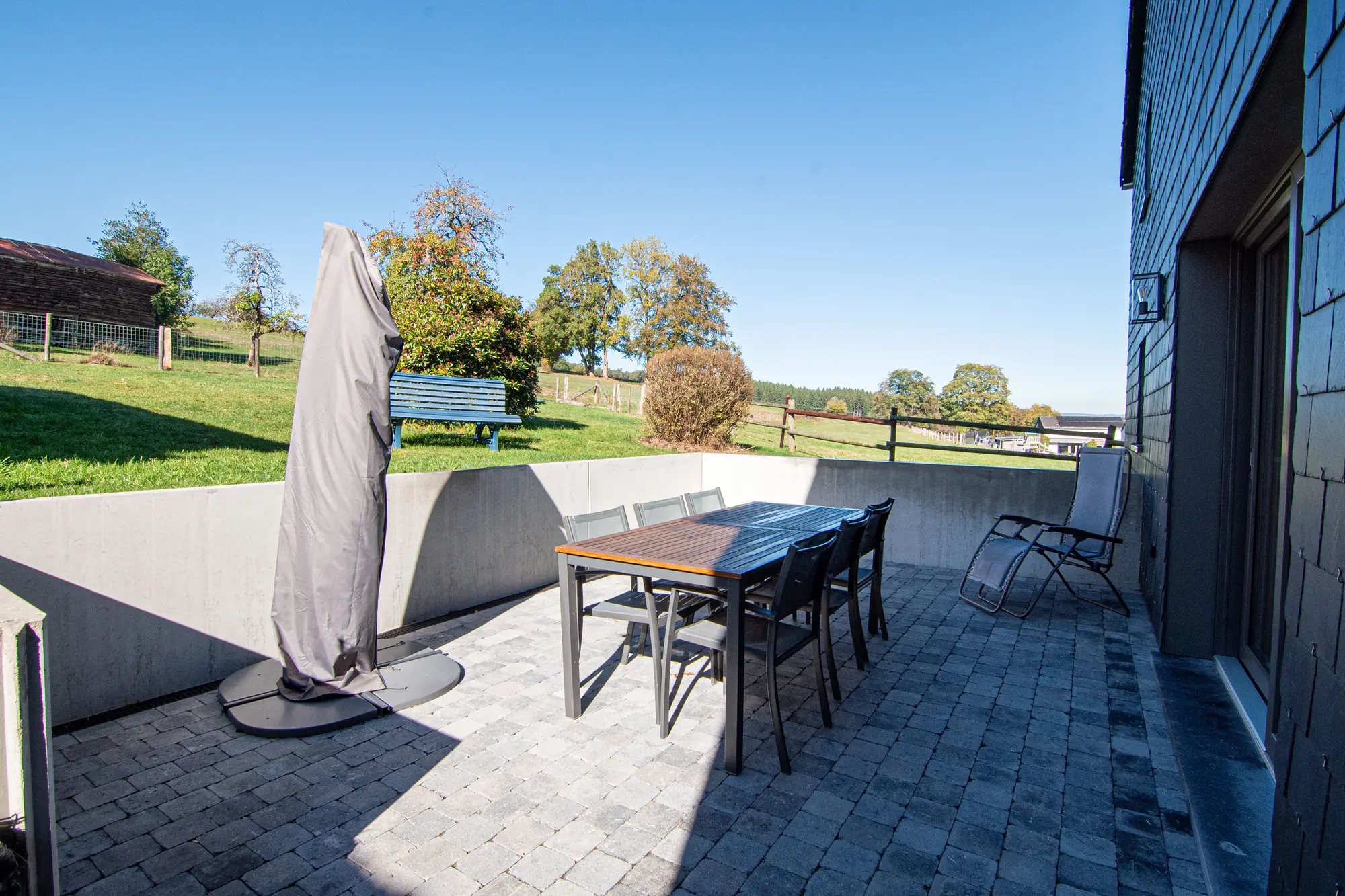 Table de repas installée sur la terrasse face au jardin